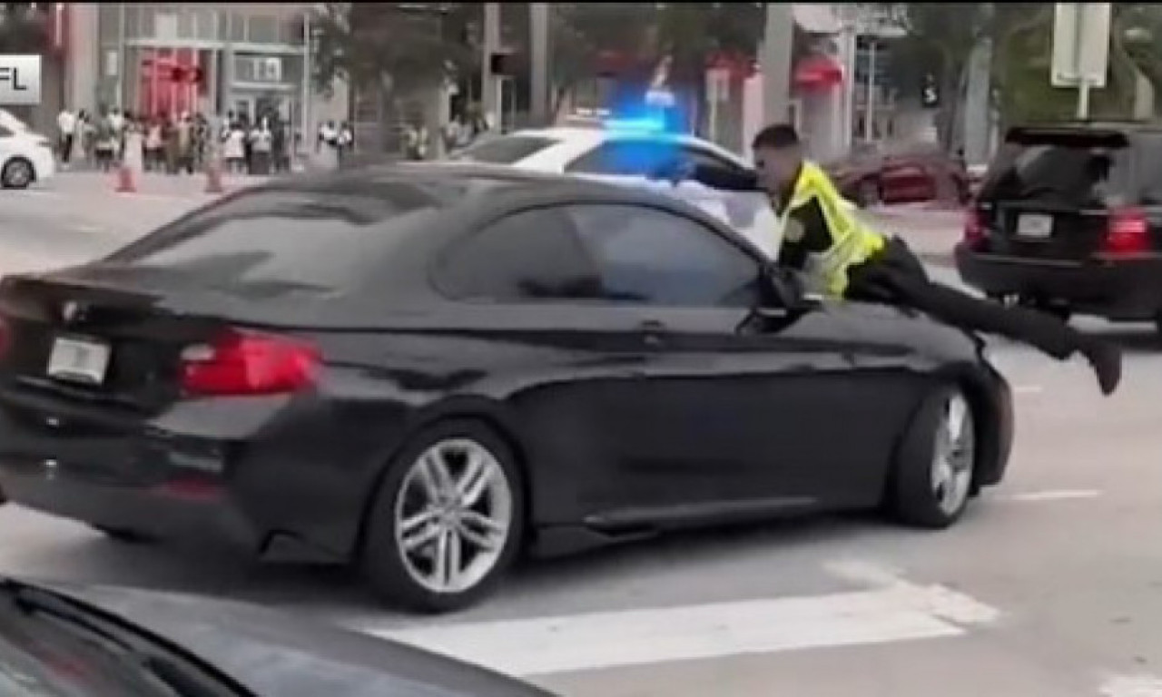 SNIMAK KOJI LEDI KRV Policajac visi na haubi i puca na vozača usred grada! (VIDEO)